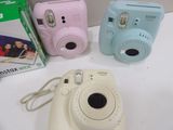 three cameras sitting next to each other on a table