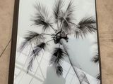 the book is sitting on the floor next to a palm tree