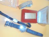 une photo montrant une montre, un peigne et d'autres objets posés sur une table