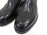 a pair of black shoes that are on a white surface