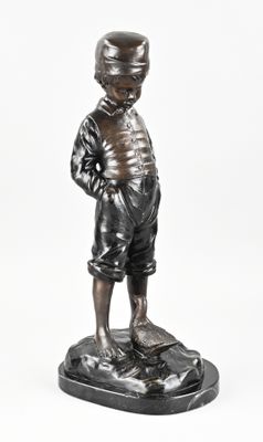 statue of a boy with a hat on his head standing on a base