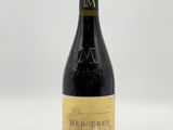 une bouteille de vin posée sur une table blanche