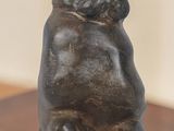 une statue représentant un lapin assis sur une table en bois