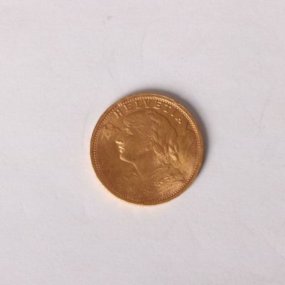 a gold coin on a white surface with a white background