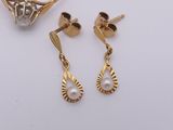 two pairs of earrings and a ring on a white surface