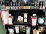 many bottles of perfume on a shelf in a store