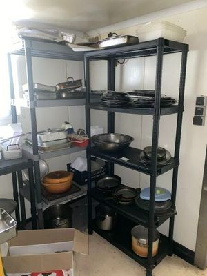de nombreuses casseroles et poêles sur les étagères de la cuisine
