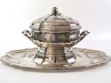a silver plate with a silver bowl on it
