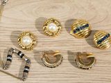 many different types of jewelry on a wooden table