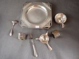 a silver plate with spoons, cups, and spoons on a table