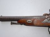 an old gun that is on display on a white surface