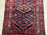 a red and blue rug with a diamond design on it