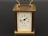 an image of a small gold clock on a black surface