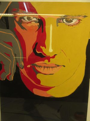 un tableau représentant le visage d'une femme, exposé dans une vitrine