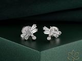une paire de boucles d'oreilles ornées de diamants, posée sur un coffret vert