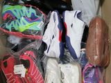 plusieurs paires de chaussures dans une boîte posée sur le sol