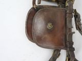 a brown leather purse hanging on a white wall