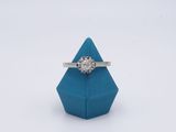 une image représentant une bague en diamant posée sur un origami bleu