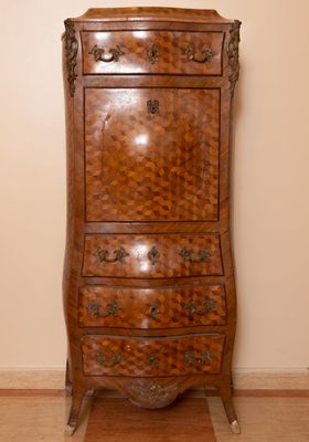 a tall wooden chest of drawers in the corner of a room