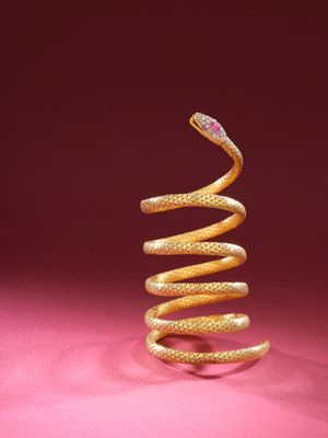 an image of a gold spiral shaped object on a pink background