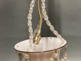 a light hanging from a chandelier made of glass beads