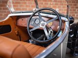 a steering and dashboard of a vintage car in a garage