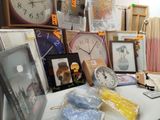 a table with a clock, picture frames, pictures, and other items on it