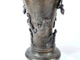 a silver vase with a bird on it on a white background