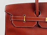 a brown leather handbag with gold hardware