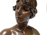 a bronze statue of a woman with a crown on her head