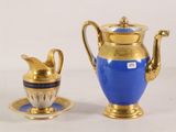 a blue and gold coffee pot and cup on a table