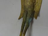 bronze statue of a bird on a white surface with a white background