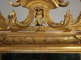 a mirror with a gold frame and a clock on top of it