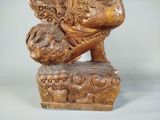 a wooden statue of a lion with a bird on it ' s back