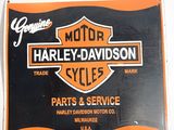 une enseigne orange et noire représentant une moto Harley-Davidson sur fond blanc