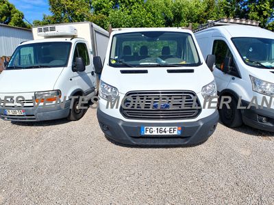 three white vans parked in a parking lot with trees in the background
