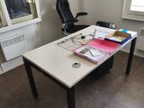 a desk with a chair and a window in the room