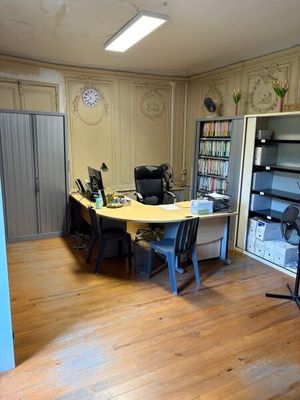 une pièce équipée d'un bureau, de chaises et d'une télévision