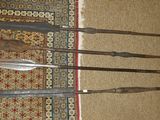 a lot of knives that are laying on a rug