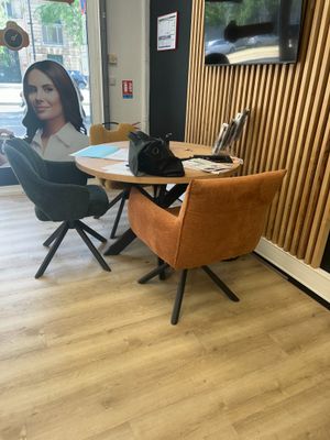 une femme assise à une table, un ordinateur portable posé devant elle