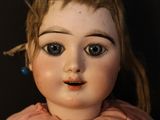a close up of a doll with a pink shirt on