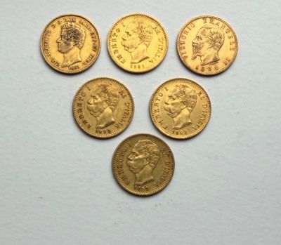six british gold sovereigns on a white surface