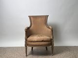 an old chair sitting on a carpeted floor in front of a white wall