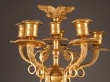 a gold candelier with a bird on top of it