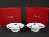 a pair of white and blue dishes with red boxes on a black background