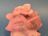 un gros plan d'un objet en plastique rose posé sur une surface bleue