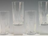 quatre grands vases en verre posés sur une surface blanche