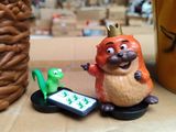 a figurine of a squirrel with a cell phone on a table