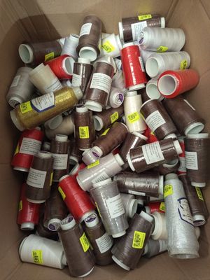a cardboard box full of different colored spools