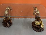 une table en verre sur laquelle trône une statue en bronze